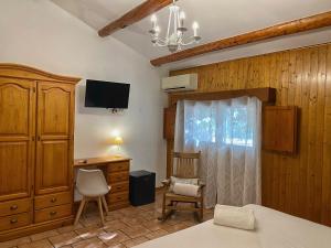 代尔特布雷三角洲酒店的一间卧室配有一张床、一张书桌和一台电视。