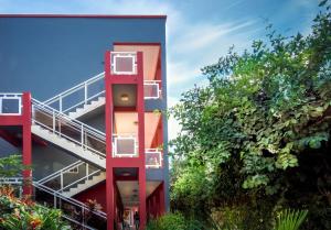 科洛里海景花园酒店 的一座红色的建筑,楼梯靠近一些树木