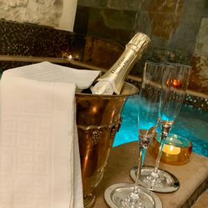 Torricella in SabinaArenarius Home Resort & SPA的一张桌子上摆放着一瓶香槟,配上两杯