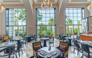 立咯海滩The Danna Langkawi - A Member of Small Luxury Hotels of the World的餐厅设有桌椅和大窗户。