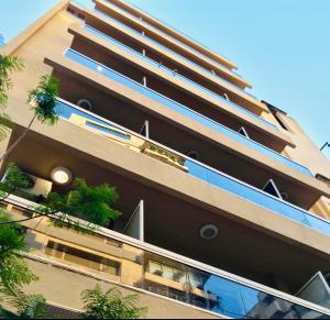 贝鲁特Divan Hotel Apartments的一座高大的建筑,上面有窗户和植物