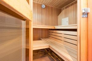 于伯林根Apart Hotel Stadtgarten的小型桑拿浴室设有木墙和木架