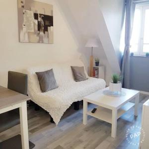 卡布尔Cosy appartement dans une villa avec piscine, proche du centre et de la mer的客厅配有床和桌子