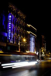 伯萨Dimen Hotel的一座晚上在上面标有蓝色标志的建筑