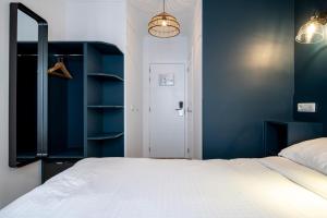 布鲁塞尔贝弗利山酒店的卧室配有白色的床和蓝色的墙壁