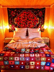 斯勒尼克Pensiunea PORTAS RESORT的一间卧室配有一张带五颜六色被子的床