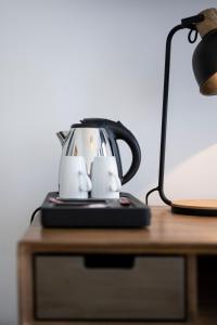 布鲁塞尔贝弗利山酒店的茶壶坐在台灯旁边的桌子上