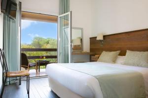 维琪奥港圣乔瓦尼酒店的一间带一张白色大床的卧室和一个阳台