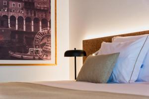 蓬塔德尔加达Canadiano Urban Nature Hotel的一张带白色枕头的床和一张墙上的照片