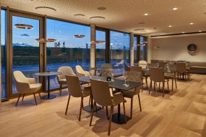 诺德奈Hotel Misan的餐厅设有桌椅和大窗户。