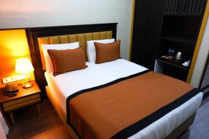 伯萨Dimen Hotel的一间卧室配有一张带枕头的大床
