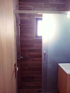 阿吉亚努美利卡里普索酒店的带淋浴的浴室和木墙