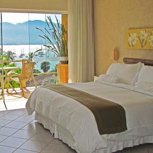 伊利亚贝拉Hotel Itapemar - Ilhabela的一间卧室设有一张床,享有海景