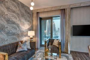 迪拜Durrani Homes - Designer 2BR Apt with stunning Burj khalifa and Fountain View的带沙发和电视的客厅