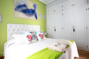 马德里Milla De Oro的一间卧室配有白色的床和绿色的墙壁