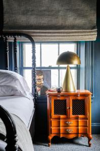 波特兰Blind Tiger Portland - Danforth Street的一间卧室配有一张床和一张带台灯的桌子
