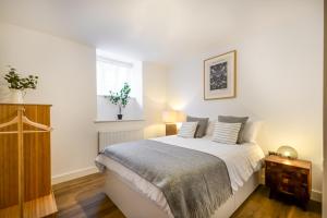 切斯特Concorde House Luxury Apartments - Chester的一间卧室配有一张带白色床单的床和一扇窗户。
