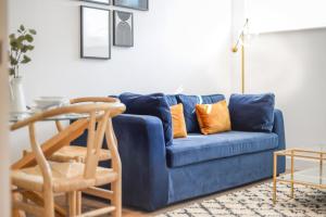 切斯特Concorde House Luxury Apartments - Chester的客厅里配有带橙色枕头的蓝色沙发