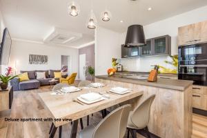 奥帕提亚Apartments Liana的厨房以及带桌椅的起居室。