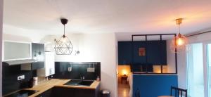 TalangeBrit's Studio的厨房配有蓝色橱柜和2盏吊灯