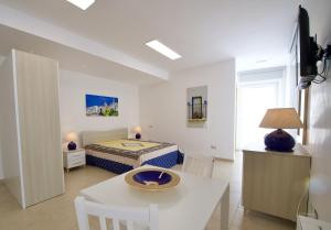格罗塔列Domus Le Ceramiche的白色的客厅配有床和桌子