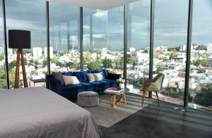 瓜达拉哈拉Suites BQ的卧室配有蓝色沙发,位于大窗户前