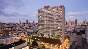 旧金山Holiday Inn San Francisco - Golden Gateway, an IHG Hotel的一座高大的建筑,城市里灯火通明