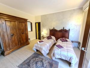 萨尔扎纳B&B Al Calcandola的一间卧室设有两张床和木制床头板