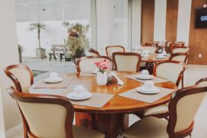 圣安娜-利弗拉门图Confort Fronteira Hotel的一间带木桌和椅子的用餐室