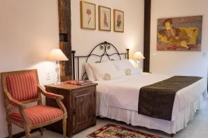 蒂拉登特斯Pouso da Torre的一间卧室配有一张床、一把椅子和一张桌子