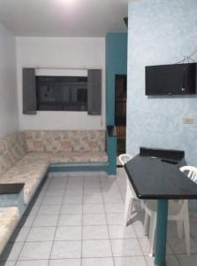 卡拉瓜塔图巴Pousada NOVA Catavento的客厅配有沙发和桌子