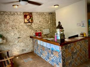 巴卡拉尔Yaxche Centro Hostal y Camping的餐厅内的酒吧,墙上有瓷砖