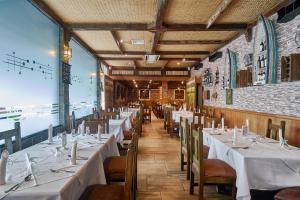 圣多明各里亚索尔酒店的餐厅的一排桌子,配有白色的桌布