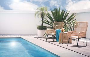 高雄高雄福華大飯店的一个带两把椅子的庭院和一个游泳池