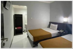 GabungLosmen Family Syariah Bypass Juanda Mitra RedDoorz的小房间设有两张床和镜子