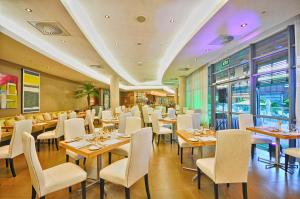 蓝海湾Holiday Inn Mauritius Mon Trésor, an IHG Hotel的配有木桌和白色椅子的餐厅