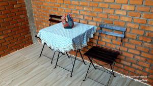 范县奥姆胡姆民宿的砖墙旁的一张桌子和两把椅子