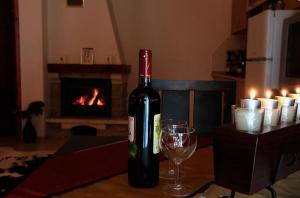 潘波洛沃Ski Villa in Pamporovo Forest的一瓶葡萄酒和一杯放在餐桌上的壁炉