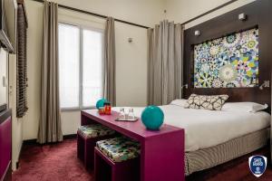 巴黎库尔赛乐之星酒店的一间卧室配有一张大床和一张紫色的桌子