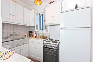 普拉提伊亚洛斯西弗诺斯Sifnos Residence的厨房配有白色橱柜和冰箱。