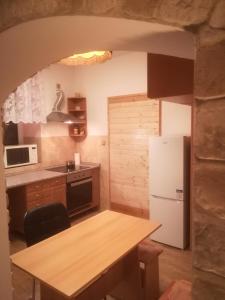 捷克斯卡利采Apartmány pod Barunčinou školou的厨房配有桌子和白色冰箱。