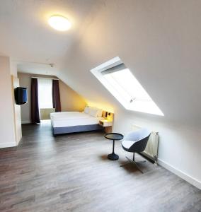 霍根海姆Taste Hotel Hockenheim的大型客房设有床和天窗。