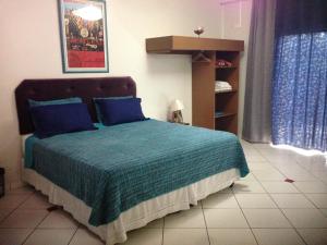 伊通比亚拉贝拉里约宾馆的一间卧室配有一张带蓝色枕头的床
