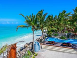 江比阿Casa Paradis的棕榈树和海洋海滩上的游泳池
