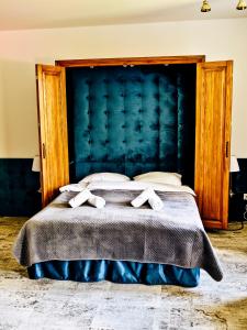 普扎斯内什Dwór Karwacz的一间卧室配有一张大床和蓝色床头板