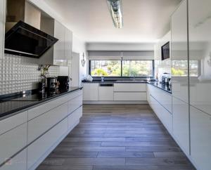 卡瓦利亚尔Home Beach Dream House的厨房铺有木地板,配有白色橱柜。