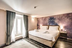 罗马四头私人套房旅馆的卧室配有一张大床,墙上挂有绘画作品