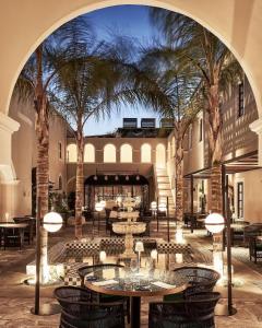费拉Katikies Garden Santorini - The Leading Hotels Of The World的庭院设有桌椅,棕榈树