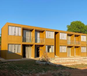 戈亚斯州上帕莱索Delú Residences的一座橙色的建筑,旁边设有阳台