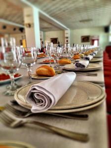 奥利文萨海莱德罗酒店的长桌,带盘子和叉子,酒杯